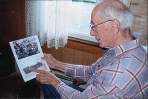 2005, Amos looking at photo of the bow of the LST 282